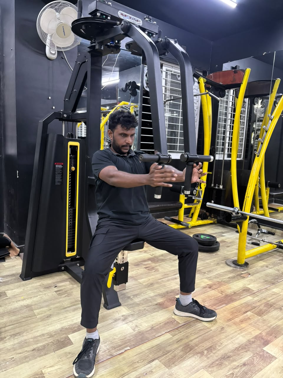 Member training on a resistance machine on IMFIT’s third floor